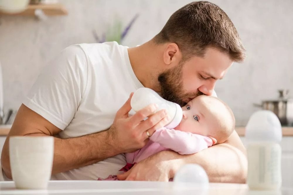 Padre alimentando a su bebé, ejemplo de prueba de paternidad en bebés por DNA en CASA