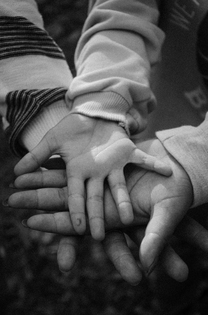 Manos de varias generaciones de una familia, representando las raíces y la ascendencia genética que revela una prueba de ADN